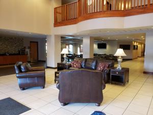 En el vestíbulo hay una sala de estar con sofás y sillas. en Wingate by Wyndham Coon Rapids, en Coon Rapids