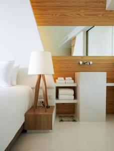 メーピンにあるセンタラ Q リゾート ラヨーンのベッドルーム1室(ベッド1台、ランプ付きテーブル付)