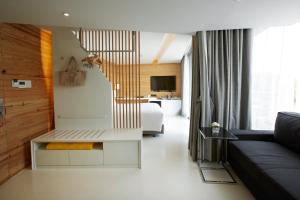 a living room with a couch and a bed at Centara Q Resort Rayong in Mae Pim