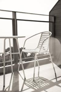 una silla blanca sentada junto a una mesa en un balcón en Centara Q Resort Rayong en Mae Pim