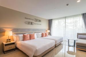 a hotel room with two beds and a couch at Centara Ao Nang Beach Resort & Spa Krabi - SHA Plus in Ao Nang Beach