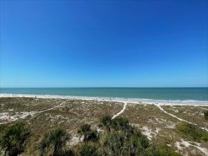 einen Strand mit Palmen und dem Meer in der Unterkunft All Seasons Vacation Resort by Libertè in St Pete Beach