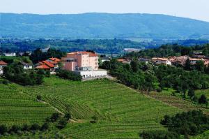 une petite ville sur une colline avec une ferme dans l'établissement Hotel Kozana, à Dobrovo