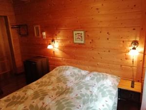 1 dormitorio con 1 cama en una pared de madera en Tahkonhovi Golden Chalet, en Tahkovuori