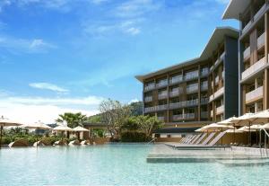 a hotel with a swimming pool with umbrellas at Centara Life Phu Pano Resort Krabi in Ao Nang Beach