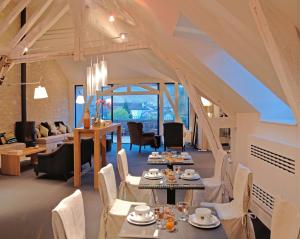 a dining room with tables and chairs and a living room at Au Vieux Moulin in Chablis