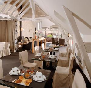 une salle à manger avec des tables et des chaises avec de la nourriture dans l'établissement Au Vieux Moulin, à Chablis