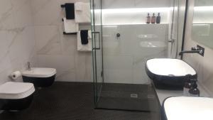 a bathroom with a shower and a toilet and a sink at Franklin38 in Auckland