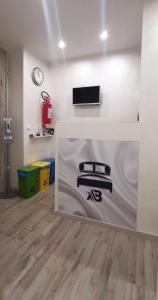 Habitación con pared blanca y TV en la pared. en A&B Affittacamere a Boccadasse en Génova