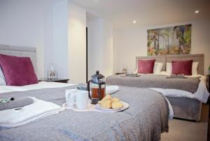 Zimmer mit 2 Betten und einem Tablett mit Essen in der Unterkunft The Dragon's Den in Harrogate