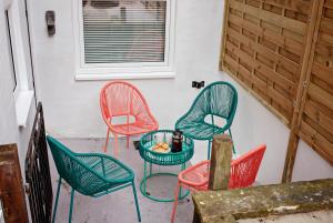 eine Gruppe Stühle und ein Tisch auf einer Terrasse in der Unterkunft The Dragon's Den in Harrogate