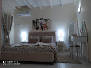 Agis Residence في Ágios Rókkos: غرفة نوم بسرير ومكتب فيه مصباحين