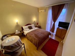 a bedroom with a bed and a television in it at Hotel Park in Negotino