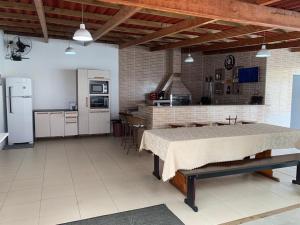 a large kitchen with a table in a room at Casa com piscina in Porto Belo