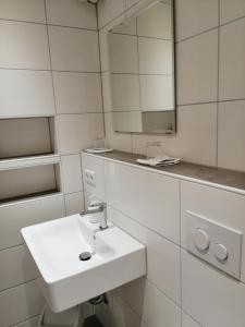a white bathroom with a sink and a mirror at Landhotel Reckenberg in Stegen
