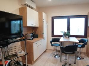 a kitchen with a tv and a table and chairs at Apartment GNUBBEL am Wald in Weißwasser