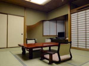 uma sala de jantar com uma mesa de madeira e cadeiras em Kinokuniya Yusenkan em Hakone