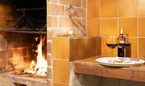 アルクーディアにあるEs Fasserの暖炉の横のカウンターに座るワイン2杯