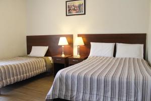 Habitación de hotel con 2 camas y 2 lámparas en El Solar Inn, en Arequipa