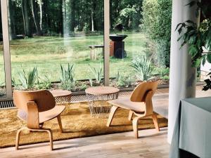 twee stoelen en een tafel voor een raam bij The Oak in Waver