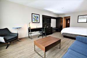 a hotel room with a bed and a desk and a bed and a couch at Holiday Inn Express & Suites - Forney by IHG in Forney