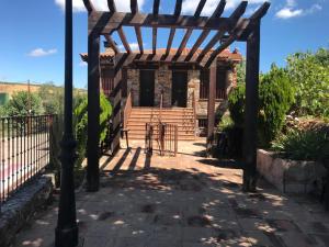 uma pérgola de madeira em frente a uma casa em Alojamiento rural "LA JARA" em Robledillo de la Jara