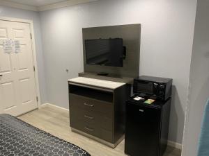 een kamer met een bed, een televisie en een bureau bij Mirage Inn & Suites in San Francisco