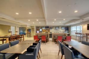 a dining room with wooden tables and chairs at Holiday Inn Express Hotel & Suites Oshkosh - State Route 41 by IHG in Oshkosh