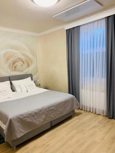 ロガシュカ・スラティナにあるSLOAPART Apartmentsのベッドと大きな窓のある寝室