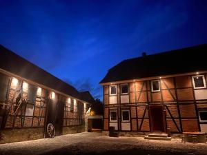 kilka budynków jest oświetlonych w nocy w obiekcie Mario's fachwerkhaus am Huy w mieście Schlanstedt