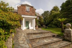 an external view of a house with a stone walkway at Boscundle Manor in St Austell