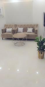 sala de estar con sofá y mesa en Iwaa Alkharj Apartments, en Al Kharj