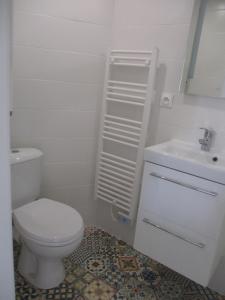 biała łazienka z toaletą i umywalką w obiekcie Petite maison à deux pas du centre et des plages w mieście Quiberon