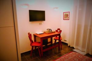a room with a table and two chairs and a television at Entre montagnes et lac in Armoy