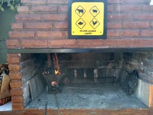 a brick fireplace with a yellow danger sign on it at La Vilma Hospedaje Familiar in Paganini