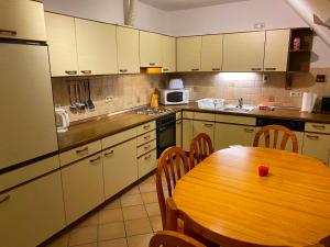 a kitchen with a wooden table and a kitchen with a table and a wooden table at Ferienwohnung Dinkelscherben in Dinkelscherben
