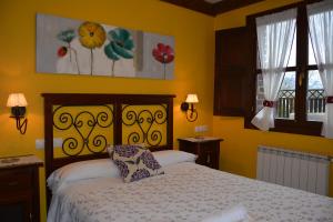 - une chambre avec un lit aux murs jaunes dans l'établissement Apartamentos Rurales Piedrafita, à Llenín