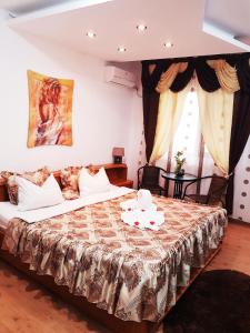 a bedroom with a bed with a table and a window at Pensiunea Red Rose Apartments in Timişoara