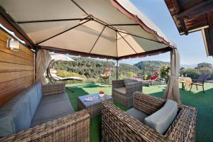 un patio extérieur avec des chaises et un parasol dans l'établissement Felsenegg, à Nalles