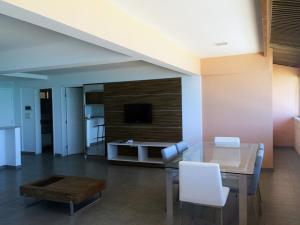 a living room with a dining table and a tv at Atlântico Hotel Maceió in Maceió