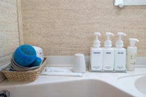 a bathroom counter with bottles of soap and a sink at Tabist Hotel Mercury Asakusabashi in Tokyo