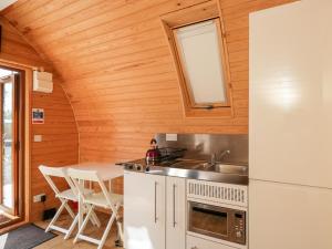 eine Küche mit Spüle und Tisch in einem winzigen Haus in der Unterkunft Halmore Pod in Berkeley + 11 Fotos