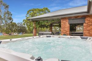 a hot tub in the backyard of a house at Hunter Valley Vineyard Large Family Farm Houses - Ironstone Estate Lovedale in Lovedale
