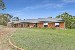 a brick house with a large yard in front of it at Hunter Valley Vineyard Large Family Farm Houses - Ironstone Estate Lovedale in Lovedale