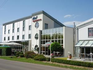 a large white building with a lot of windows at Hotel Seehof Leipzig in Zwenkau