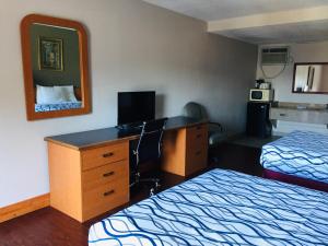 a room with a bedroom with a desk and a bed at Bear Mount Inn & Suites in Pigeon Forge
