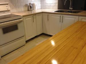 a kitchen with white cabinets and a wooden counter top at Apt Near Downtown in Montréal