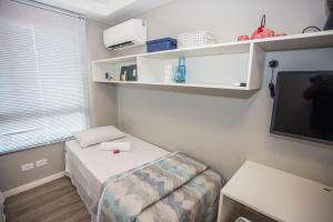 a small room with a bed and a tv at Studio com 2 Camas de Solteiro - ALL0703 in Curitiba +29 photos