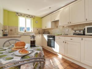 a kitchen with a table with a sandwich on it at Springfield Cottage in Chipping