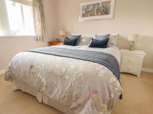 a bedroom with a large bed with blue pillows at Springfield Cottage in Chipping